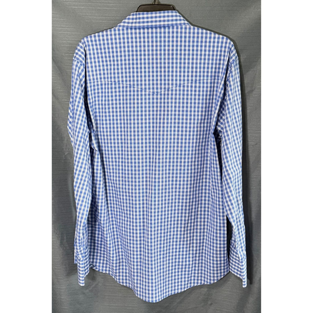 Back of Wrangler men's blue and white plaid long sleeve Western shirt with pointed collar and curved shirttail hem.